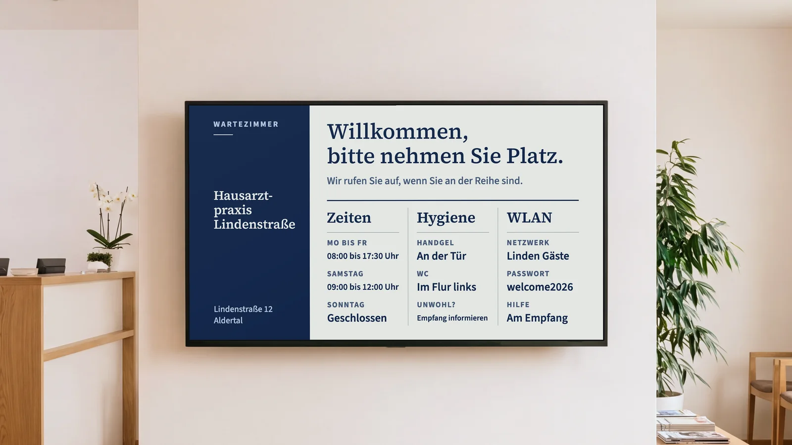 Wartezimmer einer Hausarztpraxis mit einem Blick auf den Empfangstresen, Wartestühlen aus Eiche und einem Bildschirm an der warmweißen Wand. Er zeigt Hausarztpraxis Lindenstraße und „Willkommen, bitte nehmen Sie Platz.“, darunter Zeiten, Hygiene, WC und WLAN.