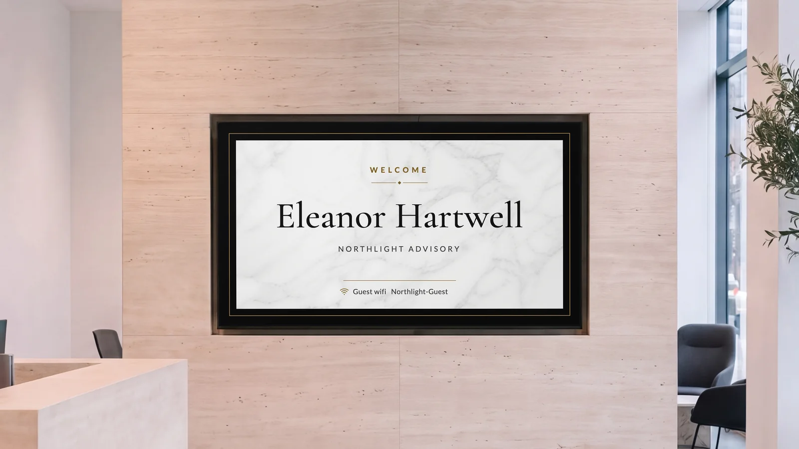 Office reception with a screen set into a travertine wall, the edge of a stone reception desk and a lounge chair at the sides. The screen reads Welcome, Eleanor Hartwell, Northlight Advisory.