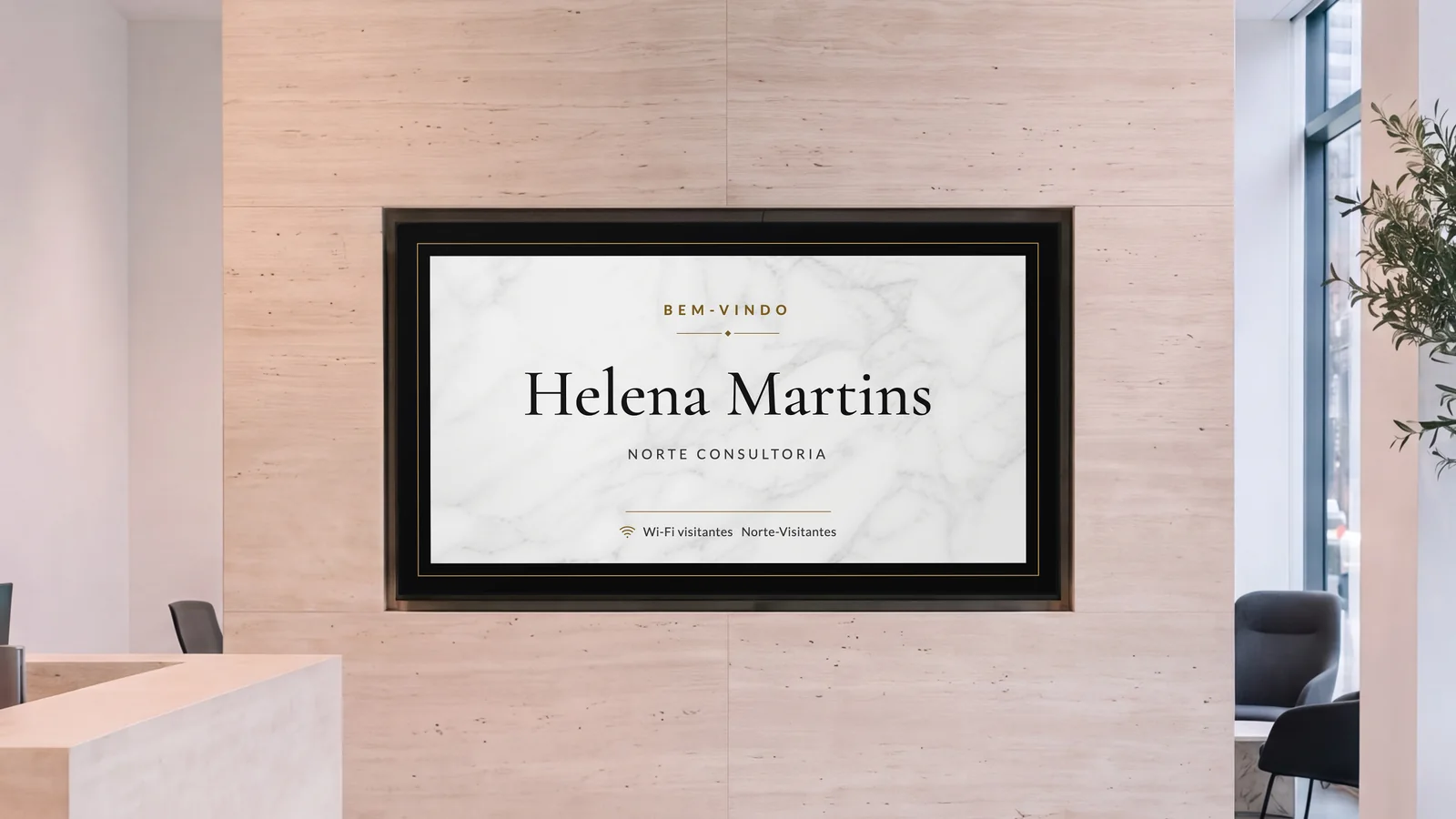 Recepção de um escritório com uma tela embutida numa parede de travertino, a ponta de um balcão de pedra e uma poltrona ao lado. A tela mostra: Bem-vindo, Helena Martins, Norte Consultoria.