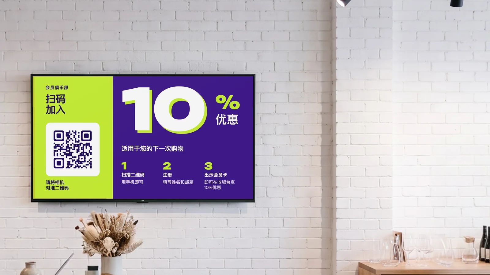 礼品家居店，收银台后方的白色砖墙上挂着一块屏幕，水磨石台面上摆着干花，旁边的架子上是陶瓷。屏幕显示会员俱乐部：扫码加入，下一次购物享10%优惠。
